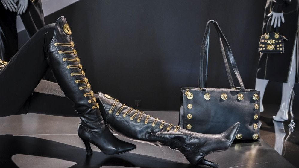 Leather boots and a bag with gold elements presented at the exhibition.