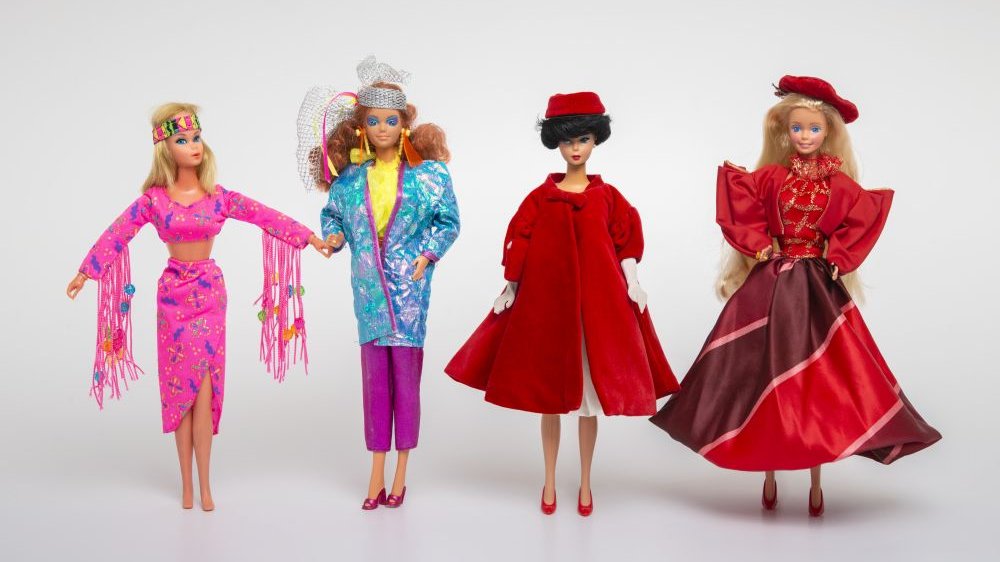 Photo of four Barbie dolls dressed in various colourful clothes.