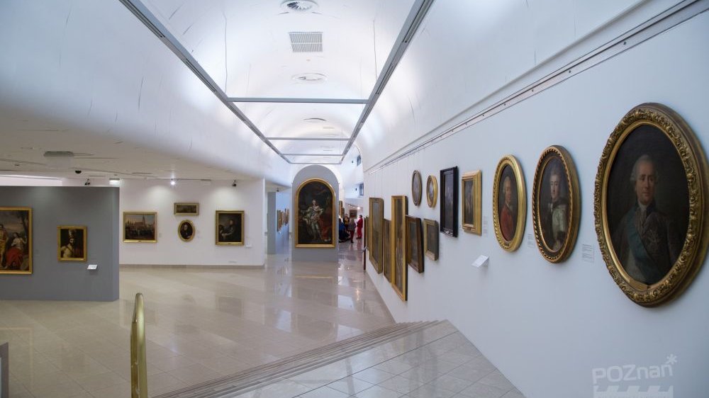 Sala jednej ze stałych wystaw muzeum, białe ściany, na których wiszą obrazy, głównie portrety, w złotych, zdobionych ramach.
