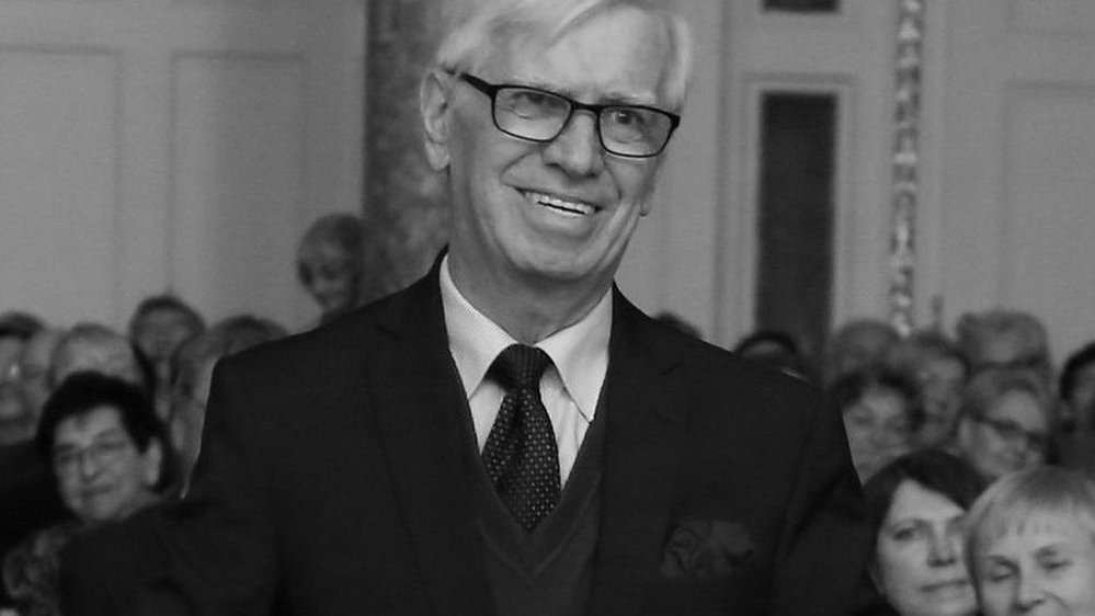 Czarno-biały portret starszego mężczyzny w okularach.