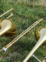 Picture of two trombones lying on the grass