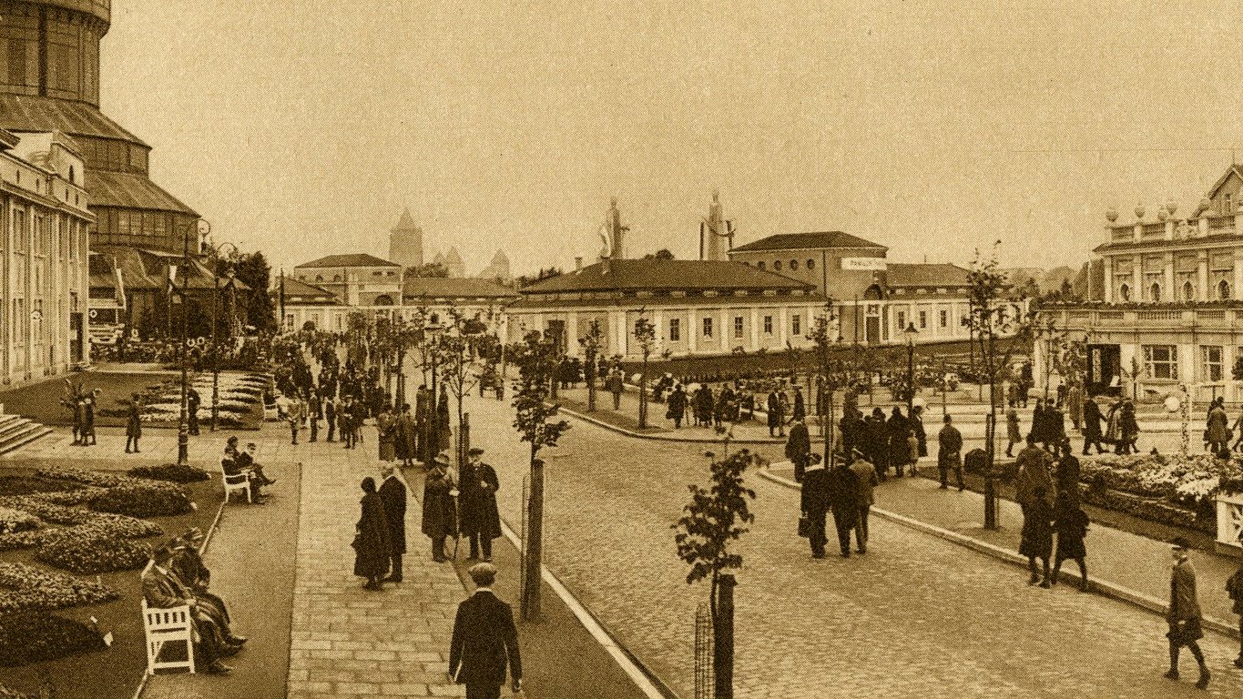 Photo in sepia colours from the beginning of 20th century: fair buildings and people walking around