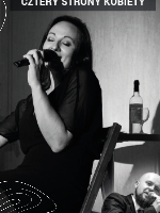 Black and white photo of a woman singing to the microphone.
