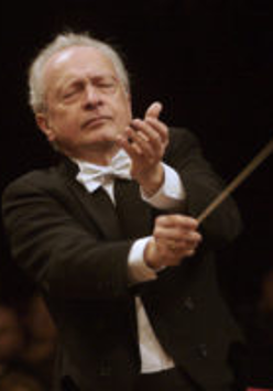 Photo of the conductor - a man with a conductor's baton in his hand on a black background