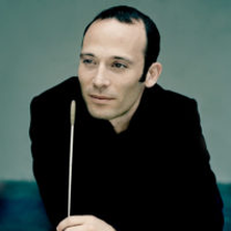 Photo of the conductor - a man in black clothes with conductor's baton