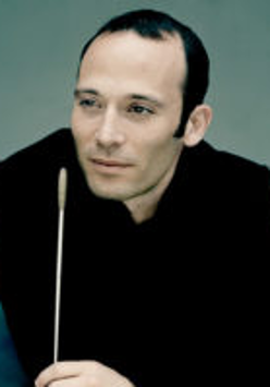 Photo of the conductor - a man in black clothes with conductor's baton