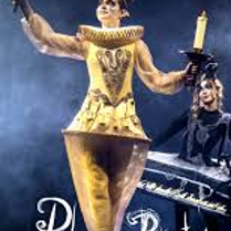 Photo of a woman dressed in a golden Lumiere (candelabra) costume against a dark background