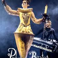 Photo of a woman dressed in a golden Lumiere (candelabra) costume against a dark background