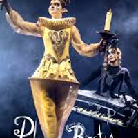 Photo of a woman dressed in a golden Lumiere (candelabra) costume against a dark background