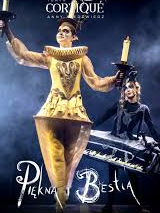 Photo of a woman dressed in a golden Lumiere (candelabra) costume against a dark background