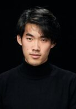 Photo of the pianist - a man in black clothes on a black background