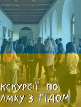 Photo of group of people in a corridor, listening to a young woman. Blue and yellow colours.