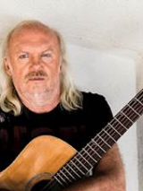 Photo of Andrzej Skorowski who holds a guitar.