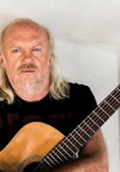 Photo of Andrzej Skorowski who holds a guitar.