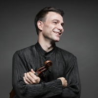 Photo of the artist, Amihai GROSZ, who is holding the violin in his hand
