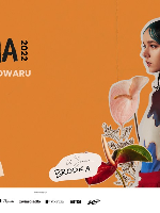 Picture of the artist on orange background among flowers