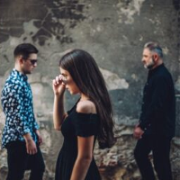 Photo of the band: one woman and two men.