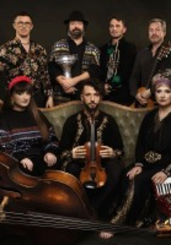 Photo of the band: seven people, three of them sitting on a sofa.