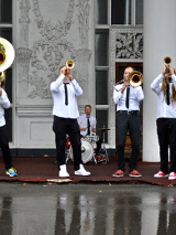 Photo of members of a band playing various musical instruments.