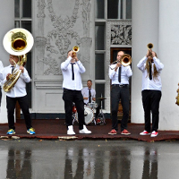 Photo of members of a band playing various musical instruments.