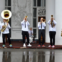 Photo of members of a band playing various musical instruments.