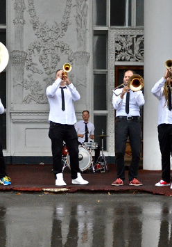 Photo of members of a band playing various musical instruments.