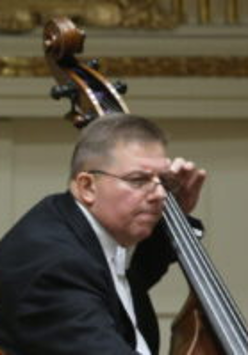 A photo of an artist Piotr Czerwiński playing double bass
