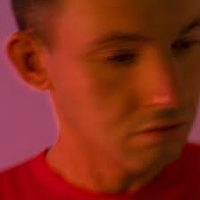 Photo of a young man's face in red and violet colours.