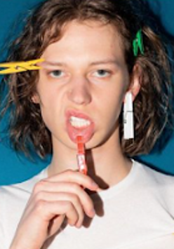 Photo of Jann - young man with laundry pegs in his hair and one on his lip.