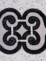 Black and grey photo of a mosaic made of small squares.