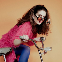 Photo of Julia Rover in sunglasses, standing by bike.