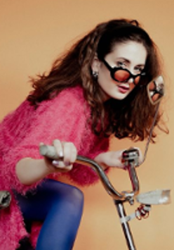 Photo of Julia Rover in sunglasses, standing by bike.