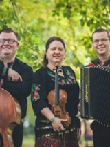 Photo of the band members:a woman and two men in folk costumes, holding their musical instruments.