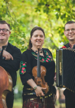 Photo of the band members:a woman and two men in folk costumes, holding their musical instruments.