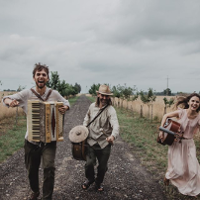 Photo of the band in folk costumes, holding musical instruments.