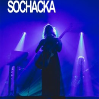 Photo of a woman on stage, blue lights.