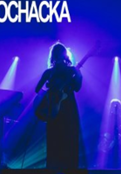Photo of Kaśka Sochacka playing the guitar on stage.