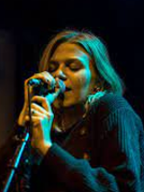 Photo of the artist singing to the microphone