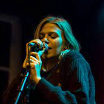 Photo of the artist singing to the microphone