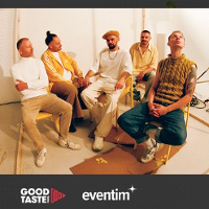 Photo of the band - five men sitting on chairs.