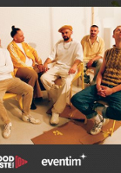 Photo of the band - five men sitting on chairs.