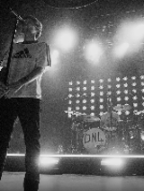 Black and white photo of Louis Tomlinson performing on stage