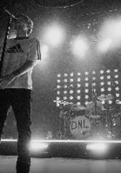 Black and white photo of Louis Tomlinson performing on stage