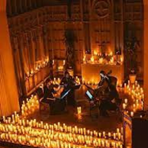Photo of two musicians on stage, around them many lit candles.