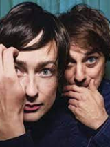 Photo of a woman and a man's faces, which are close to each other. A man and a woman touch their faces with their hands.