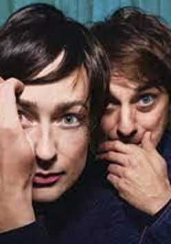 Photo of a woman and a man's faces, which are close to each other. A man and a woman touch their faces with their hands.