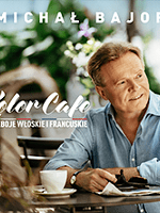 Concert poster - photo of Michał Bajor sitting at the table with a cup of coffee on it.