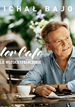 Concert poster - photo of Michał Bajor sitting at the table with a cup of coffee on it.