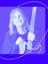 Photo in blue colours of Mike Stern, who is holding a guitar.