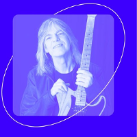 Photo in blue colours of Mike Stern, who is holding a guitar.